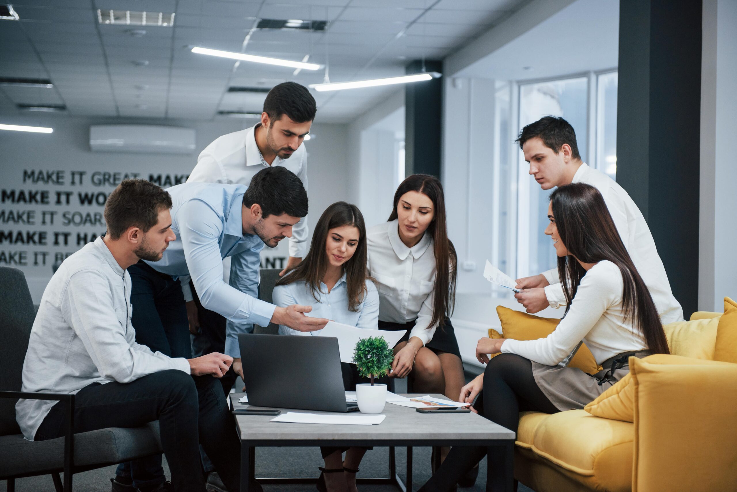 guy-shows-document-girl-group-young-freelancers-office-have-conversation-working-min